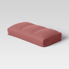 a pink pillow sitting on top of a white floor