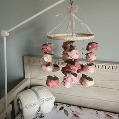 a baby crib with pink flowers hanging from it