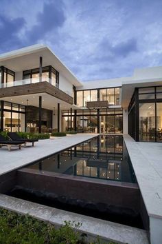 a large modern house with a pool in the front yard