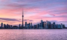 the skyline of toronto is shown at sunset