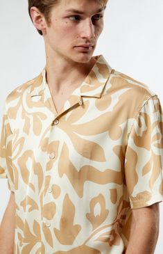 PacSun's Mari Tan Camp Shirt is a your go-to for laid-back sophistication. With its collared neckline, short sleeves, and regular fit, this shirt offers a timeless silhouette. Complete with button closures and a lightweight feel, its print throughout adds a touch of intrigue to your casual ensemble.


	Collared neckline
	Short sleeves
	Standard fit
	Button closures
	Custom pattern
	100% Rayon
	Machine washable
	Model is wearing size medium
	Model Measurements: 6'1.5” Height, 28” Waist, 32” Inseam Beige Johnny Collar Shirt With Relaxed Fit, Relaxed Fit Collar Shirt For Summer, Relaxed Fit Shirt For Summer, Beige Short Sleeve Camp Shirt For Spring, Beige Camp Shirt For Spring Vacation, Beige Relaxed Fit Camp Shirt With Short Sleeves, Beige Relaxed Fit Short Sleeve Camp Shirt, Beige Camp Collar Shirt For Spring, Beige Camp Shirt With Relaxed Fit And Camp Collar