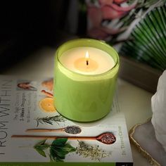 a green candle sitting on top of a book