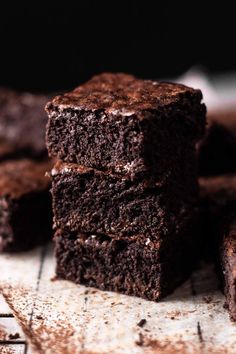 three chocolate brownies stacked on top of each other with one bite taken out of it