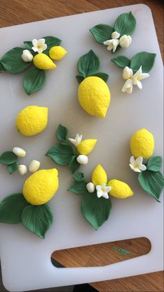 there are lemons on the cutting board with leaves and flowers cut in half to make them look like they were made out of fondant