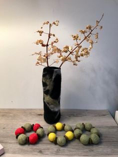 a vase filled with flowers and balls on top of a table