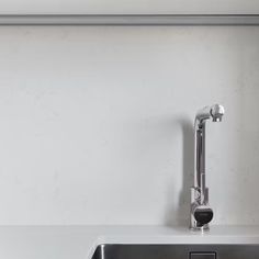 a stainless steel sink and faucet in a white kitchen with no one around it