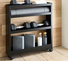 a shelf with some items on it in front of a wooden wall and wood floor