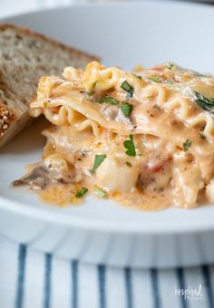 a white plate topped with pasta and bread