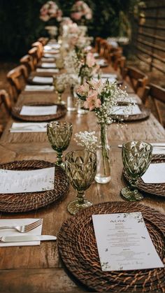 a long table with place settings and flowers in vases