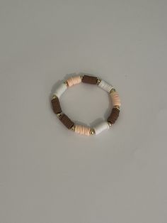 This is a super cute neutral bracelet with a coconut theme with brown, tan and white clay beads I use elastic string so it is somewhat adjustable Clay Bead Bracelet Ideas Aesthetic Brown, Casual Wooden Beads Stretch Bracelet For Beach, Casual Beach Stretch Bracelet With Wooden Beads, Casual Brown Wooden Bead Bracelets, Casual Brown Jewelry With Letter Beads, Adjustable Beige Stretch Bracelet, Casual White Stretch Bracelet With Wooden Beads, Brown Heishi Beads Bracelets Gift, Brown Heishi Beads Bracelet For Gift