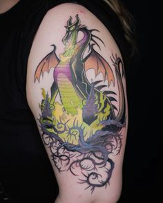 a woman's arm with a dragon tattoo on it and an orange, purple, and black design