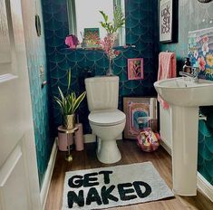 a bathroom decorated in blue and pink with the words get naked written on the floor