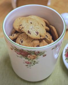 a cup filled with chocolate chip cookies on top of a table