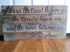 a wooden sign with the words,'bless the food before us, the family beside us and the love between us '