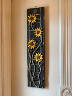 a wooden wall hanging with sunflowers on it