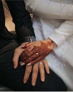 the bride and groom are holding each other's hands with hennap on their palms