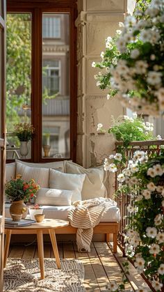 the sun shines through an open window onto a porch with white furniture and potted plants