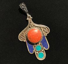 Measurements 6.5cm long, 3.5cm  in width  Metal: metal  Stone: re-process - enameled, turquoise , coral, lapis lazuli  The Hamsa hand and the Hand of Fatima are equally best known for the power to protect the owner from the evil eye and bring happiness to the holder. Traditional Cabochon Round Pendant Jewelry, Traditional Enamel Pendant Jewelry, Traditional Cabochon Jewelry With Round Pendant, Traditional Round Pendant Cabochon Jewelry, Traditional Round Cabochon Pendant Jewelry, Bohemian Enamel Jewelry With Inlay, Bohemian Enamel Inlay Jewelry, Protection Jewelry, Cool Piercings