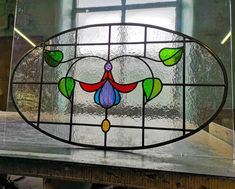 a stained glass window sitting on top of a wooden table