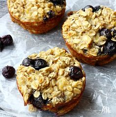 three blueberry oatmeal muffins sitting on top of wax paper