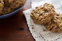 two cookies on a doily next to a bowl of oatmeal