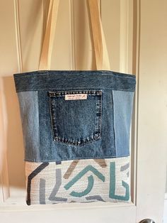 a denim tote bag hanging on a door