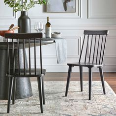 two chairs sitting on top of a rug next to a table