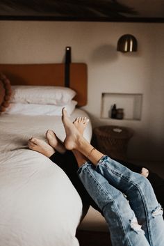 a person laying on top of a bed with their feet up