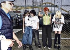 a group of young people standing on top of a wooden floor next to each other