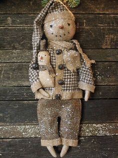 a christmas ornament hanging from the side of a wooden wall with a teddy bear