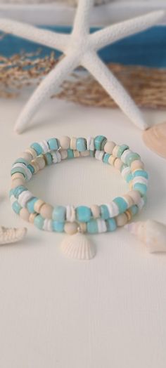 TitiTataStore.etsy.com Always FREE SHIPPING and a FREE GIFT! I Will Ship Within 24 Hours! Description: A Beautiful Set of 2 Coastal Style Ocean Inspired Beachy Bracelets. Materials: Aqua Shell Beads, 6mm Natural Matte Riverstone Beads, 6mm Natural Wood Beads, White Heishi Seashell Beads, and 6mm Rondelle Magnesite Beads.  A coastal Clam Shell charm adorned this Beachy Style set. Every bracelet is handmade using a high-quality elastic stretch cord for durability. Size: Each bracelet is suitable for a wrist circumference of about 7". Final Touch: Your bracelet will be nicely packed in a Burlap Gift Bag. ❤ All orders are shipped FREE via USPS First Class Mail with tracking number. ❤ If you would like a different size, just send me a note and I will resize it for you. Please visit my store for Beach Inspired Bracelets, Bracelets Seashell, Coastal Bracelet, Beachy Bracelets, Inspired Bracelets, Girls Trip Gifts, Burlap Gift Bags, Seashell Bracelet, Coastal Jewelry