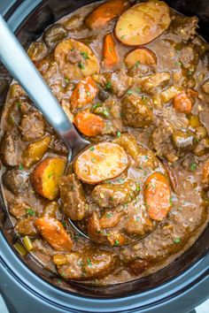 a crock pot filled with meat and potatoes, garnished with parsley