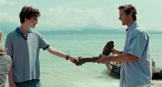 two men are shaking hands on the beach