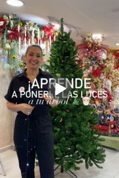 a woman standing in front of a christmas tree