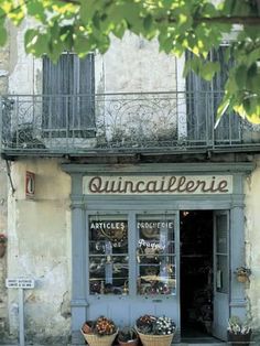 an old building with baskets of flowers in front