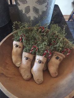 three ceramic heads with plants in them on a wooden bowl