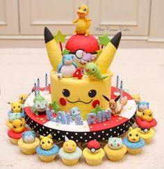 a pokemon themed birthday cake surrounded by cupcakes