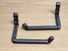 two black metal handles on a wooden table