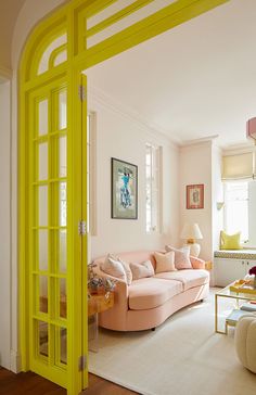 a living room filled with furniture and a yellow door