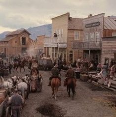 an old western town with horses and people