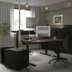 an office with two desks and a computer monitor on top of it, in front of a window