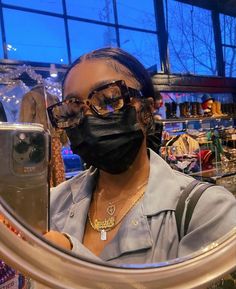 a woman wearing a face mask looking through a magnifying glass in a store