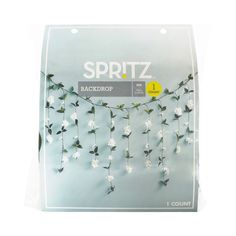 a package of white flowers hanging from a string on a wall with the words spritz back drop