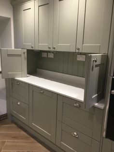 a kitchen with gray cabinets and white counter tops