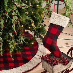 a christmas stocking sitting on top of a wooden box next to a christmas tree