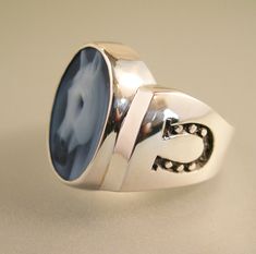 This cameo ring features a beautifully done horse head, and is made from banded agate. The ring itself is cast in sterling silver, and is nice and chunky. The horseshoes are carved deeply into the surface, and will never wear away. This is a high quality ring made in the USA. Parade worthy.... Cameo size: 18mm x 13mm Height of ring: 5mm Ring top measurement: 20mm x 20mm Bottom shank: 5mm Weight of ring: 15 grams Made to order. Over size 12 please contact me for pricing. Classic Agate Rings For Formal Occasions, Classic Agate Signet Ring For Formal Occasions, Classic Agate Signet Ring With Polished Finish, Equestrian Ring, Horse Ring, Horseshoe Ring, Cameo Ring, Over Size, Leaf Ring