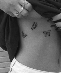 a woman's stomach with three butterflies on her side, and the bottom part of her belly