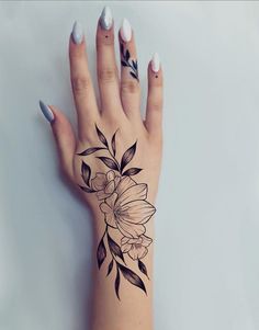 a woman's hand with a flower tattoo on it