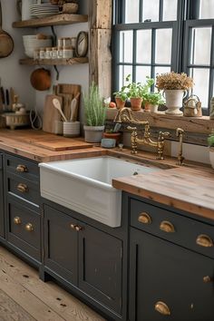 a kitchen with wooden counter tops and black painted cabinets, an old window is in the background