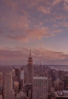 an aerial view of new york city with the empire building in the background at sunset